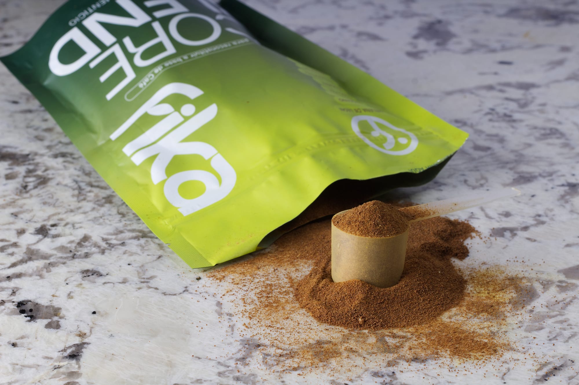 Una porción de Core Blend en polvo junto a la bolsa abierta